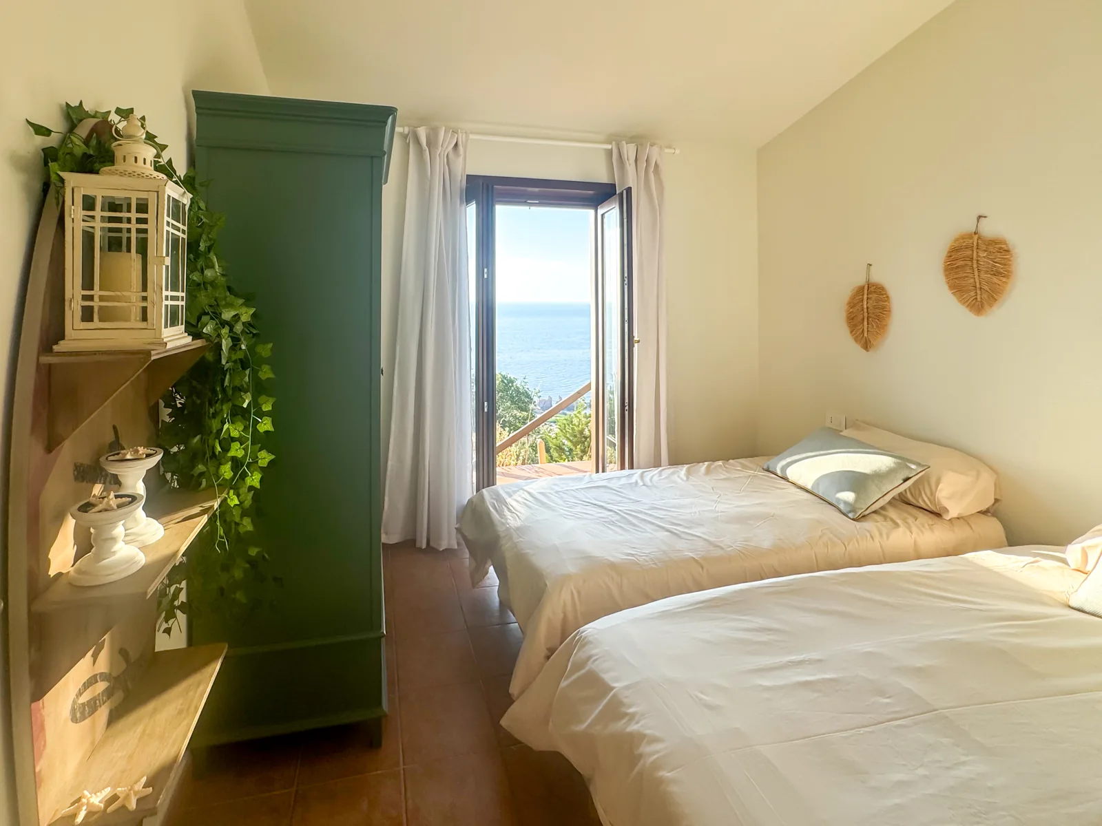 Seconda camera da letto luminosa con arredi chiari e dettagli verdi