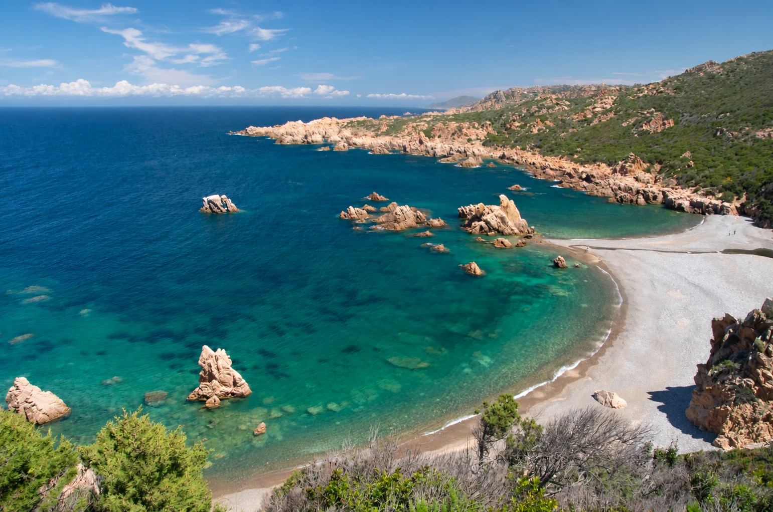 Tinnari: cala selvaggia e mare turchese La cala di Tinnari vista dall’alto, con spiaggia di ciottoli, granito rosa e mare turchese